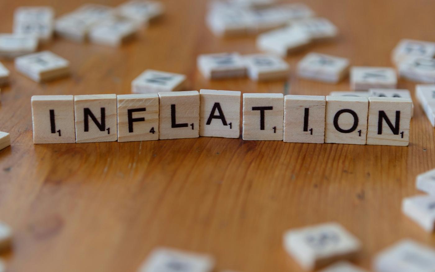 Inflation is spelled out using scrabble tiles. by Markus Winkler courtesy of Unsplash.