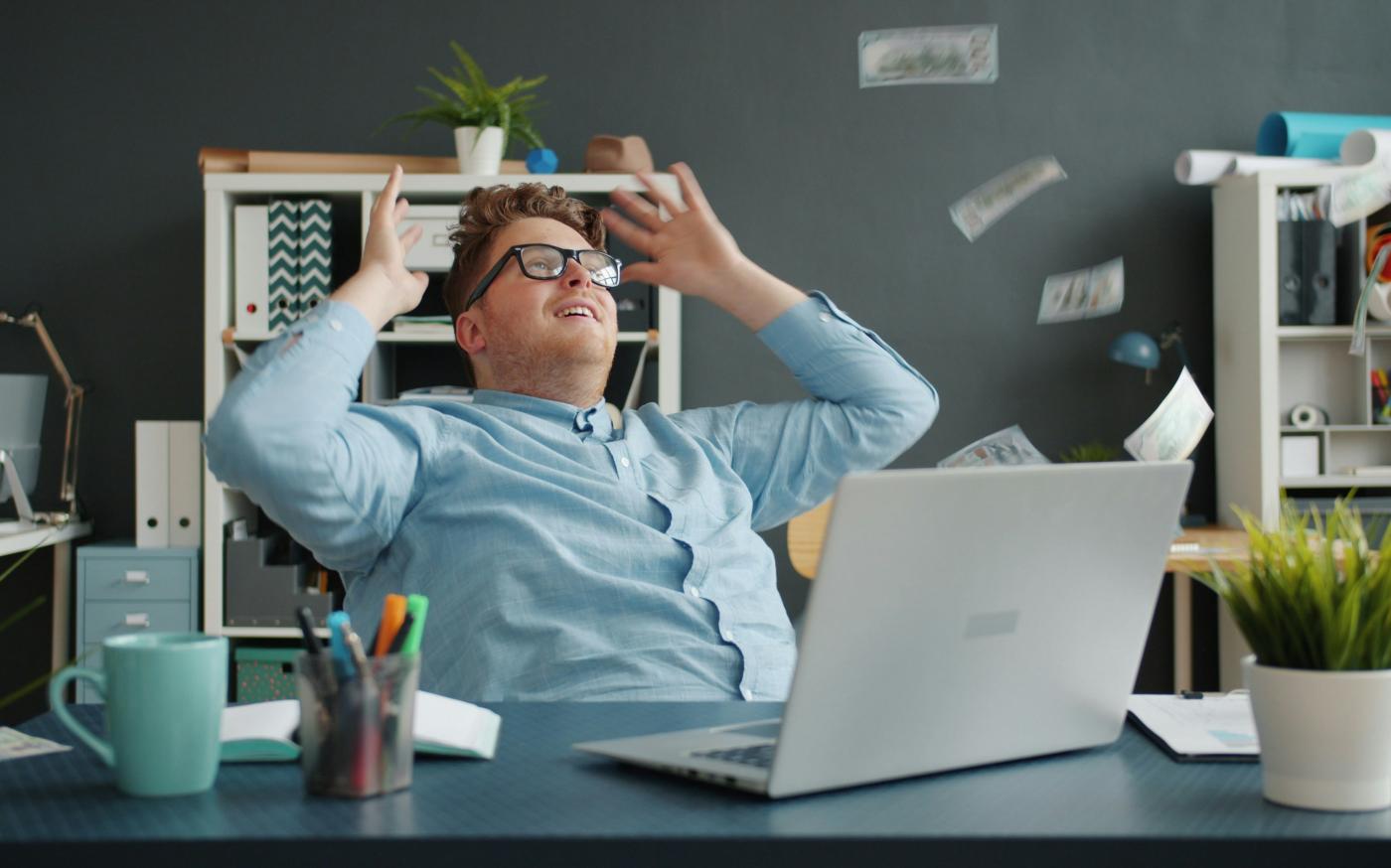 Man celebrating with money falling around him by Vitaly Gariev courtesy of Unsplash.