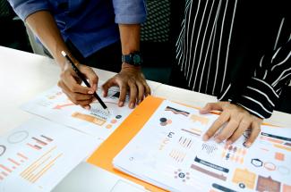 person in blue shirt writing on white paper by UX Indonesia courtesy of Unsplash.
