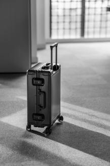 grey hard case luggage by Sun Lingyan courtesy of Unsplash.