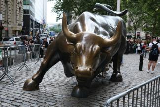 a statue of a bull on a brick street by Harri P courtesy of Unsplash.