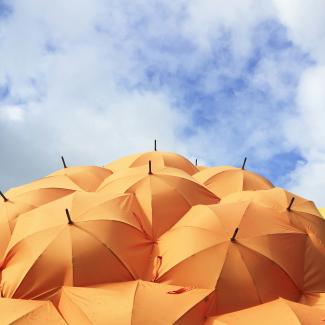 orange umbrella lot by Catrin Johnson courtesy of Unsplash.