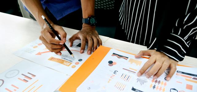 person in blue shirt writing on white paper by UX Indonesia courtesy of Unsplash.