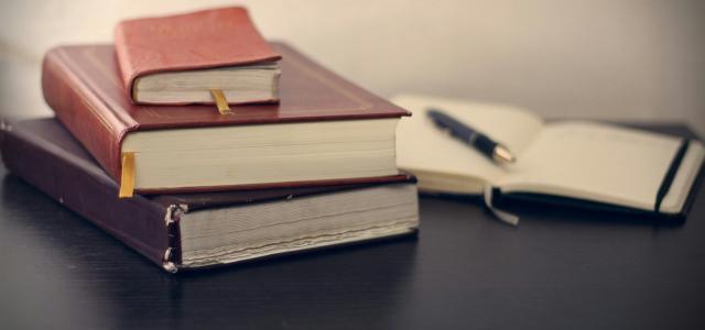 selective focus photography of three books beside opened notebook by Mikhail Pavstyuk courtesy of Unsplash.