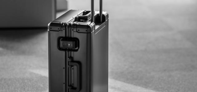 grey hard case luggage by Sun Lingyan courtesy of Unsplash.