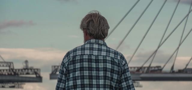 a man standing in front of a body of water by Tatiana P courtesy of Unsplash.