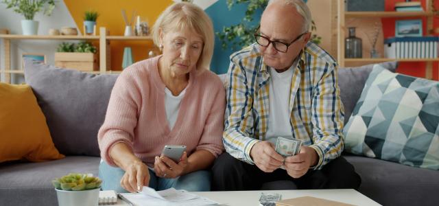 Elderly couple looking at bills and phone by Vitaly Gariev courtesy of Unsplash.